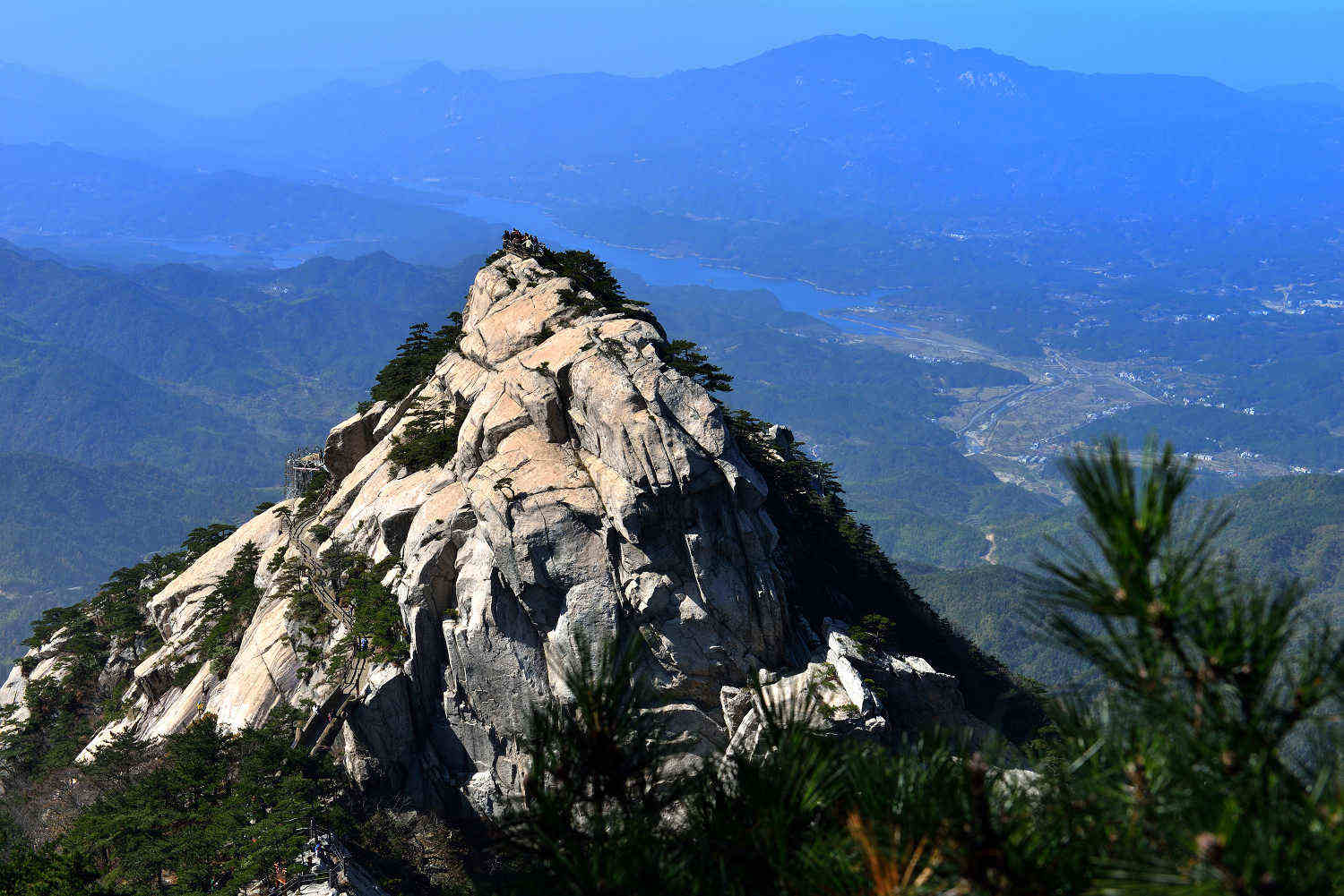 Tiantangzhai: a sunlit granite peak, pine trees and distant blue mountain ridges